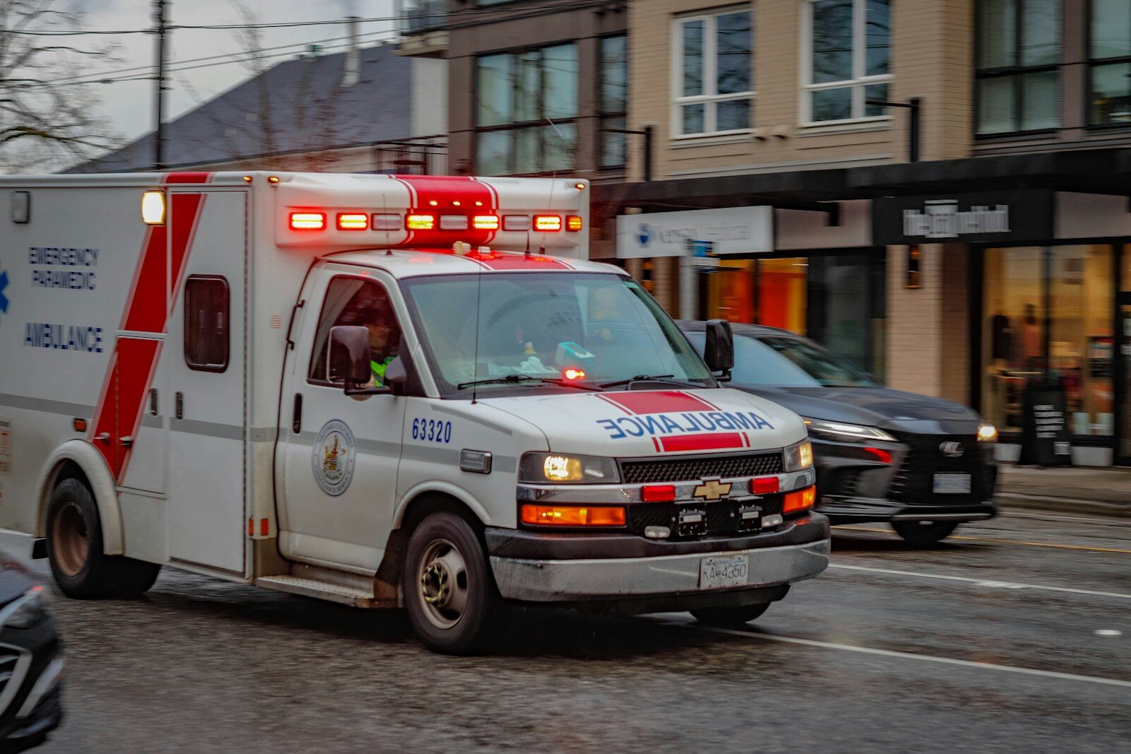 An ambulance drives down a busy city street.