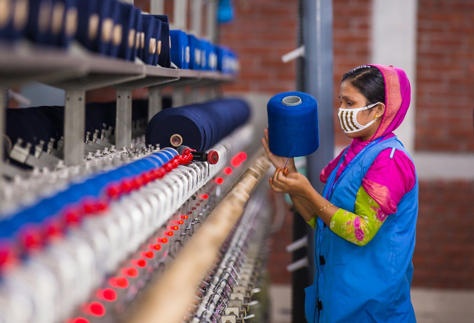 Woman working with blue yarn on a machine