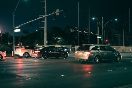 Cars waiting at a traffic light at night.